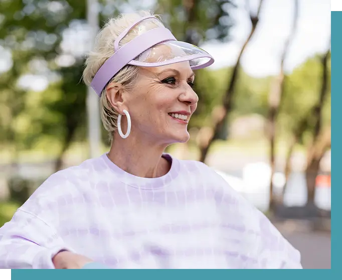 A woman wearing a visor and smiling.